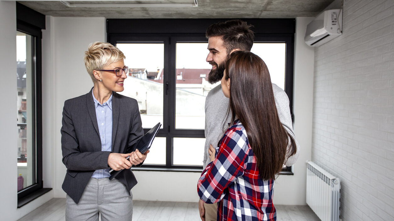 A female real estate agent is selling an apartment to a young couple.